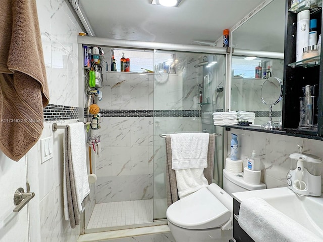 bathroom with toilet, sink, tile walls, and a shower with shower door