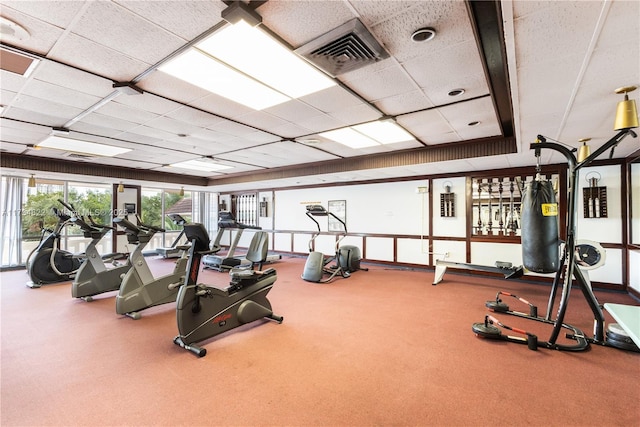 exercise room with carpet and a drop ceiling