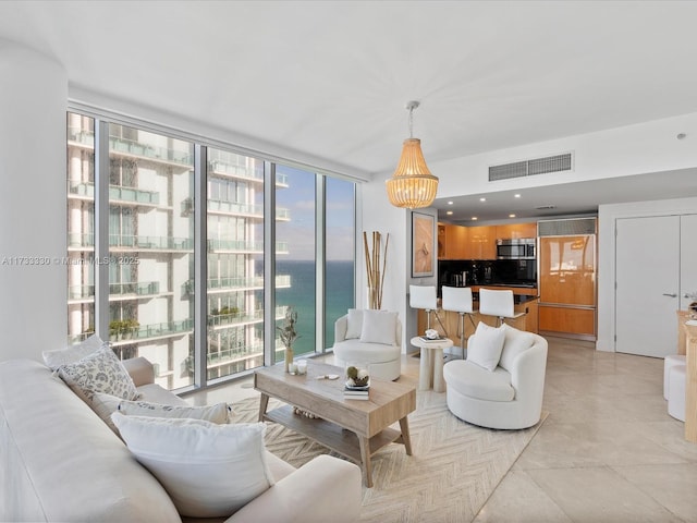 living room featuring a water view and a wall of windows