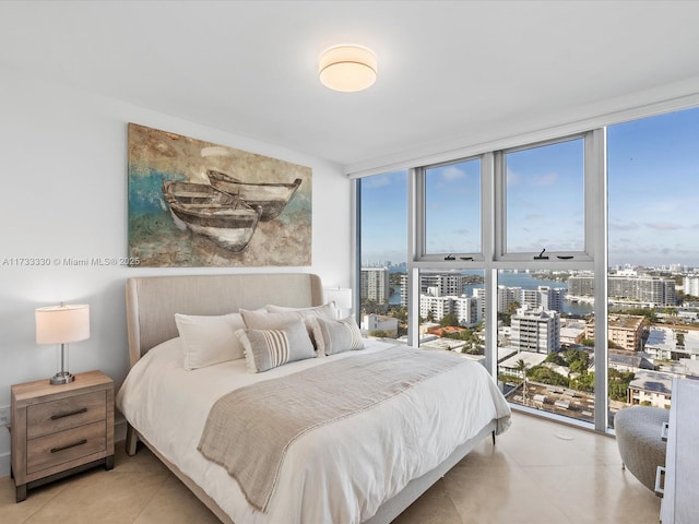 bedroom with access to outside and a wall of windows