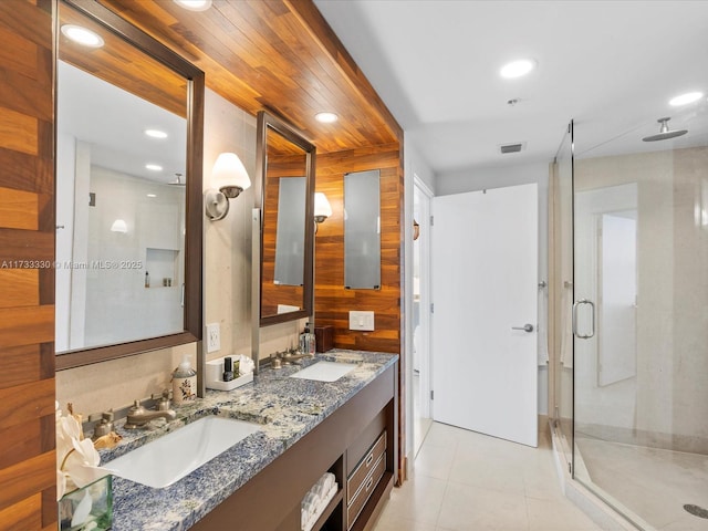 bathroom with walk in shower, tile patterned floors, vanity, and wooden walls