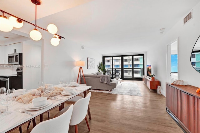 dining area featuring floor to ceiling windows and light hardwood / wood-style floors