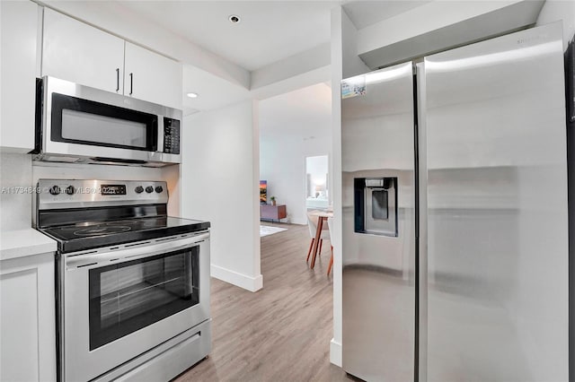 kitchen with white cabinetry, light hardwood / wood-style flooring, and appliances with stainless steel finishes