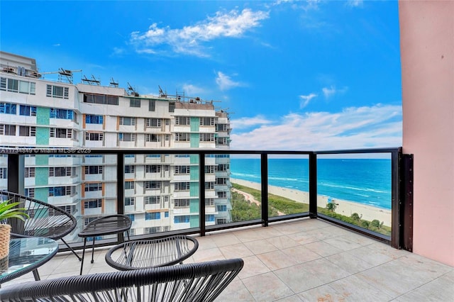 balcony featuring a water view and a beach view