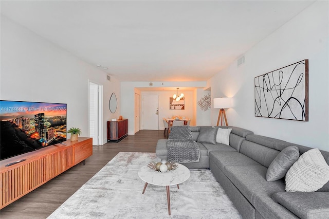 living room with dark hardwood / wood-style floors and a chandelier