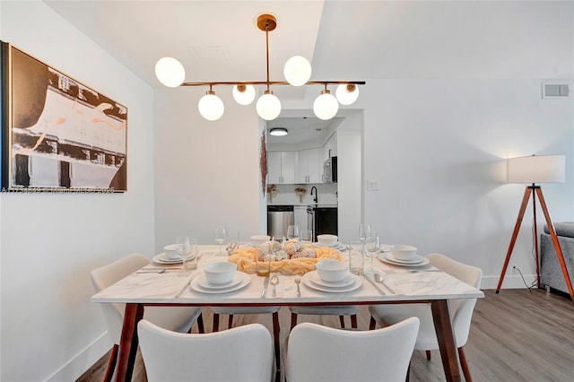 dining area with sink and hardwood / wood-style flooring