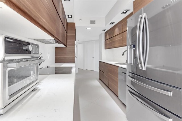 kitchen with light tile patterned flooring, appliances with stainless steel finishes, and sink