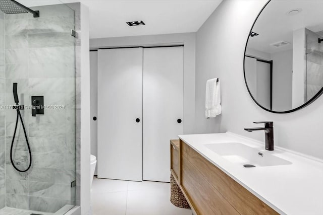 bathroom with vanity, a shower with shower door, tile patterned floors, and toilet