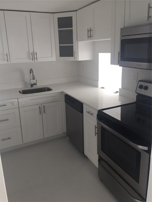 kitchen featuring appliances with stainless steel finishes, sink, and white cabinets