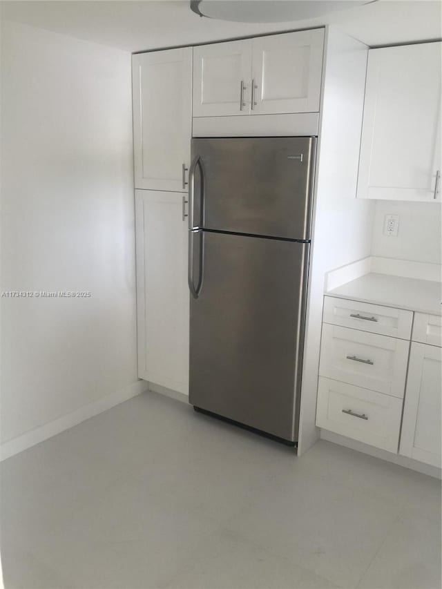 kitchen with white cabinetry and stainless steel fridge