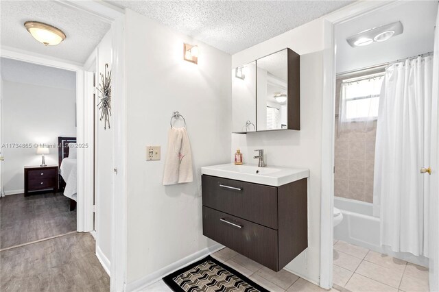 full bathroom with shower / bath combo, connected bathroom, a textured ceiling, and vanity