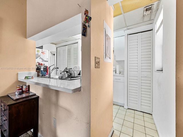 kitchen with light tile patterned flooring and a paneled ceiling