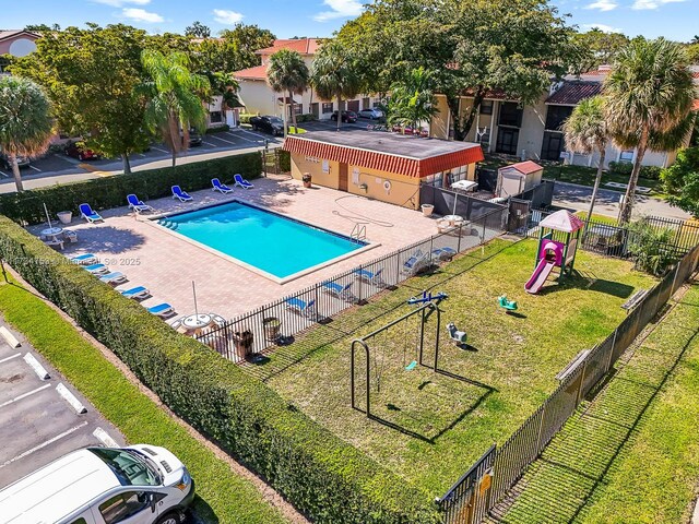 view of swimming pool featuring a playground, a yard, and a patio area