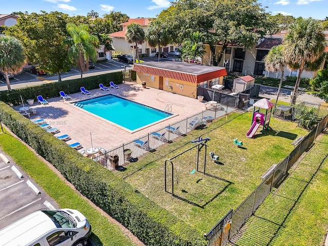 view of pool with a playground, a patio, and a yard