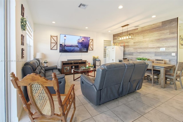 living room featuring wooden walls and light tile patterned floors