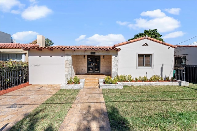 mediterranean / spanish-style home featuring a front yard and french doors