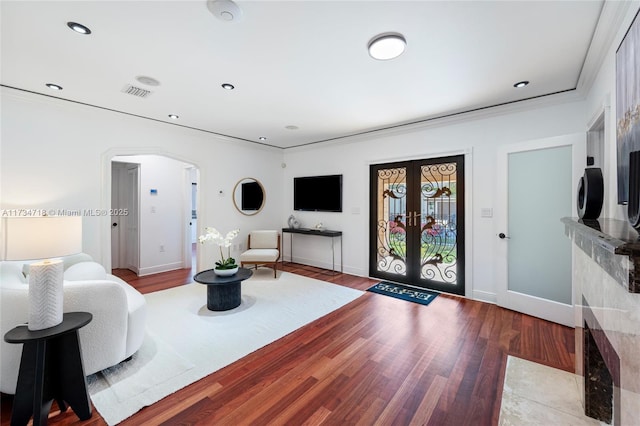 living room with crown molding, light hardwood / wood-style flooring, and french doors