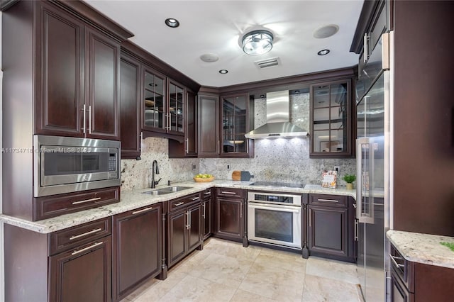 kitchen featuring stainless steel appliances, sink, backsplash, and wall chimney exhaust hood