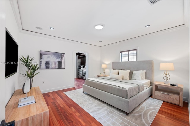 bedroom featuring ornamental molding and wood-type flooring