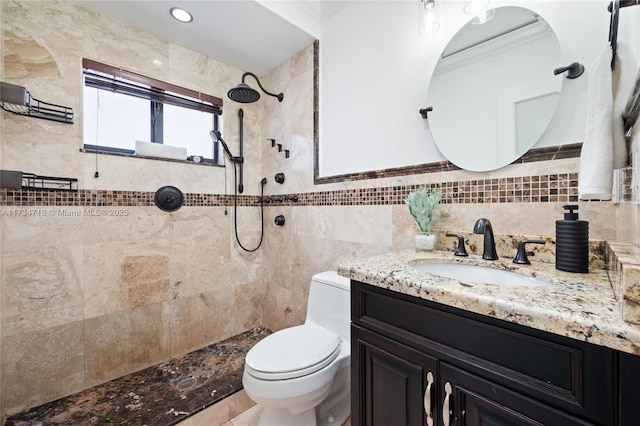 bathroom with tile walls, vanity, toilet, and a tile shower