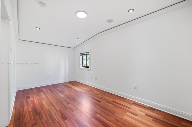 empty room featuring vaulted ceiling and wood-type flooring