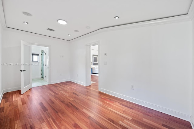 spare room featuring crown molding and hardwood / wood-style floors