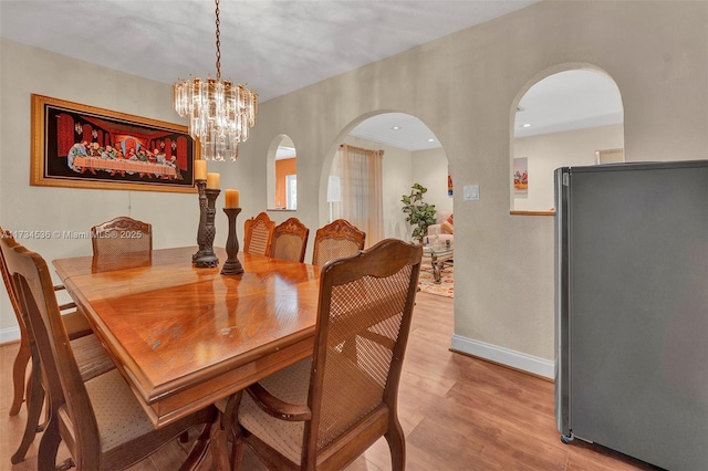 dining room with a chandelier and light wood-type flooring