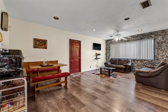 living room with ceiling fan, hardwood / wood-style floors, and a textured ceiling