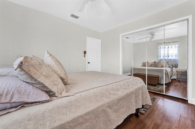 bedroom with dark hardwood / wood-style flooring, a closet, and ceiling fan