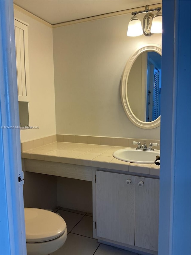 bathroom with tile patterned flooring, vanity, and toilet