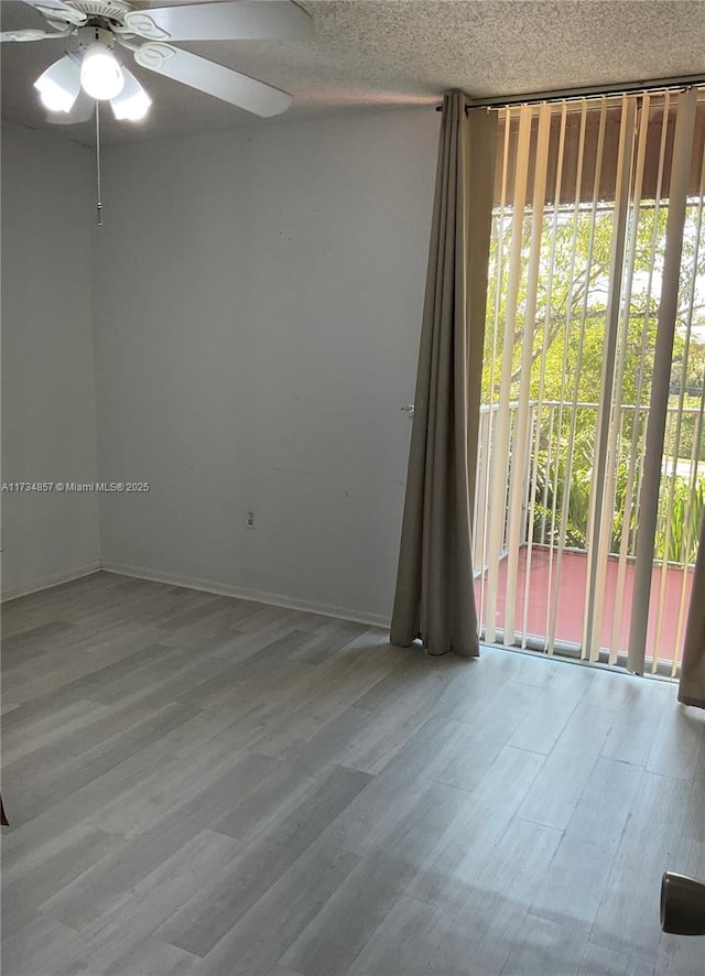 empty room featuring ceiling fan, hardwood / wood-style floors, and a textured ceiling