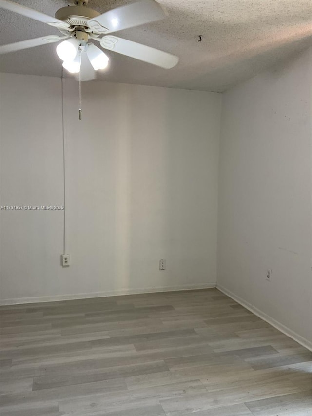 empty room featuring ceiling fan, a textured ceiling, and light hardwood / wood-style flooring