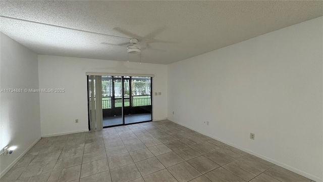 empty room featuring ceiling fan, light tile patterned floors, and a textured ceiling