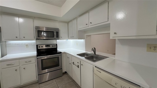 kitchen featuring white cabinetry, appliances with stainless steel finishes, sink, and light tile patterned flooring