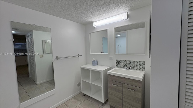 bathroom with vanity, tasteful backsplash, tile patterned floors, and a textured ceiling