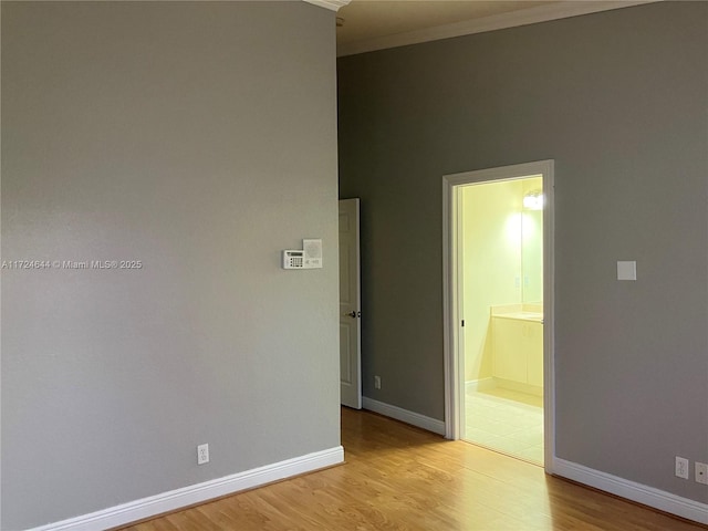 empty room featuring ornamental molding and light wood-type flooring