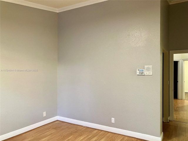 empty room featuring hardwood / wood-style flooring and crown molding