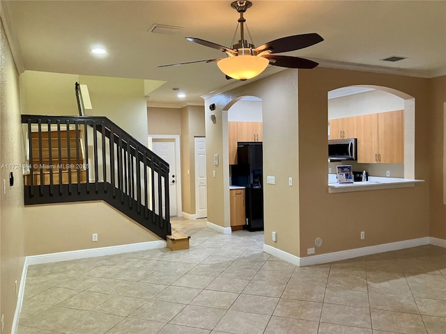 entryway with light tile patterned flooring, vaulted ceiling, ornamental molding, and ceiling fan