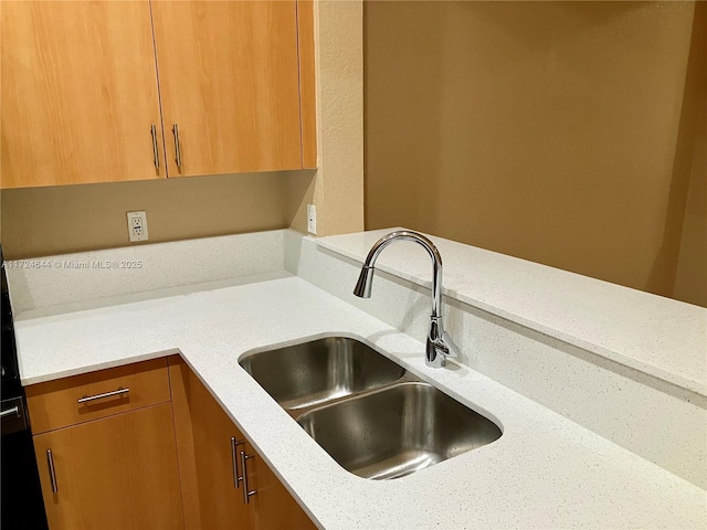 kitchen with light stone countertops and sink