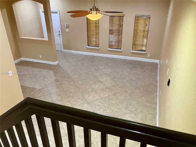 tiled spare room featuring ceiling fan