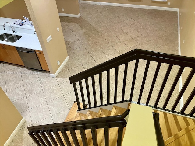 stairway featuring tile patterned flooring and sink