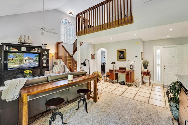 living room featuring light tile patterned flooring, ceiling fan, and high vaulted ceiling