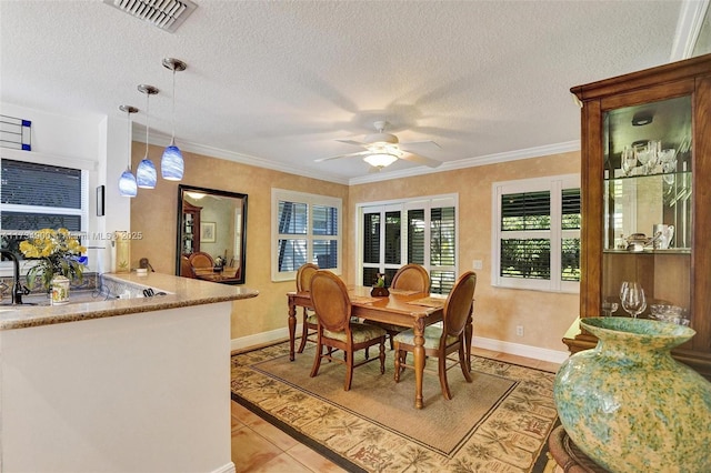 dining area featuring ornamental molding, a textured ceiling, and light tile patterned floors