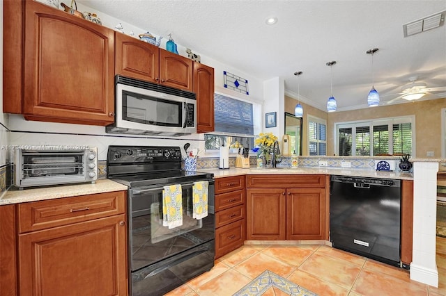 kitchen with pendant lighting, light tile patterned flooring, sink, and black appliances