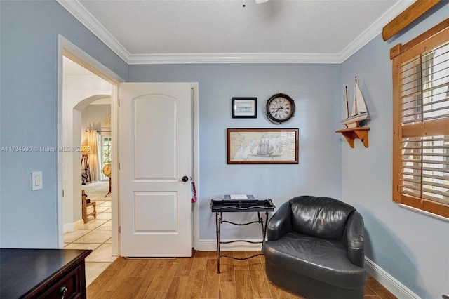 sitting room featuring ornamental molding, a textured ceiling, and light wood-type flooring