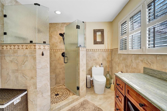 bathroom with a shower with door, tile walls, tile patterned floors, and toilet