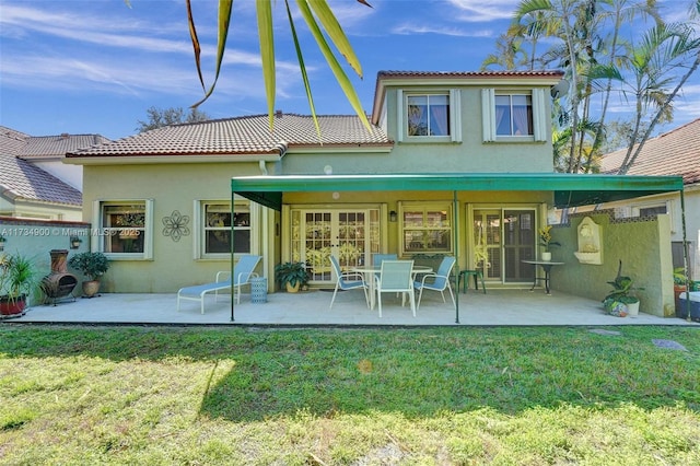 rear view of property featuring french doors, a yard, and a patio