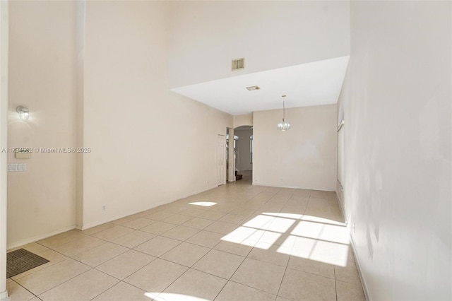 tiled empty room with a chandelier