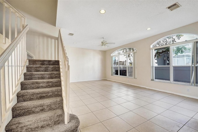 interior space featuring tile patterned flooring, ceiling fan, and a textured ceiling