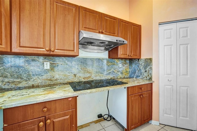 kitchen with built in desk, light stone countertops, black electric stovetop, and light tile patterned flooring